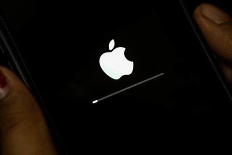 In this photo illustration a person installs updates of iOS 17.3 on an iPhone device on January 26,