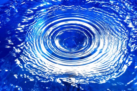 A water vortex in blue water, with concentric circles