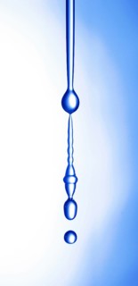 A thin stream of water from a sponge breaks off and begins to drip