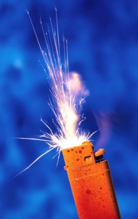An orange-red lighter sprays sparks against a blue background