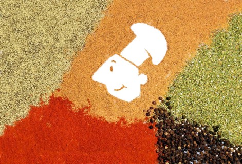 Cartoon of a chef with a chef's hat surrounded by various spices, such as red paprika, pepper and