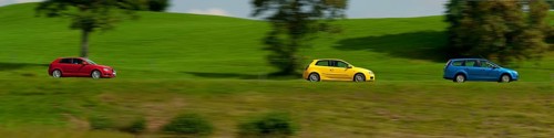 A blue, yellow and red car driving through a green landscape near Bad Kohlgrub, Bavaria, Germany,