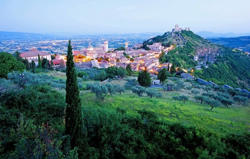 View over Assisi in the early morning, blue hour, with the Rocca Maggiore castle on a hill next to