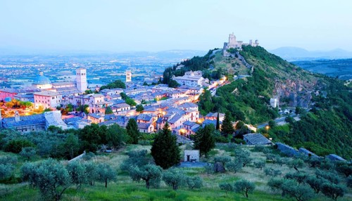View over Assisi in the early morning, blue hour, with the Rocca Maggiore castle on a hill next to