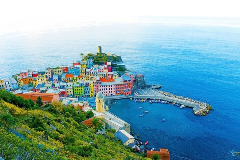 View of Vernazza in the early morning, with harbor, vineyards, colorful houses and blue