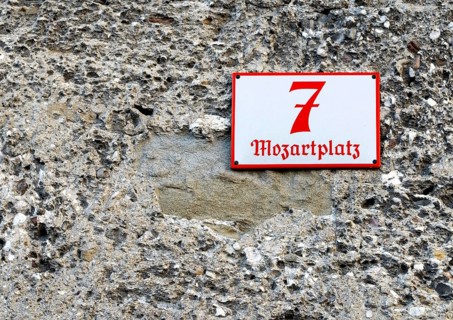 Detail of the red street number 7 on a white background on Mozartplatz, attached to an old house