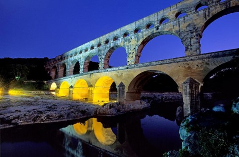 Pont du Gard in the evening light, illuminated yellow with spotlights because of an interview about