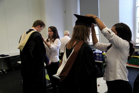 Graduating students being dressed in gown and mortarboard, Goldsmiths, University of London,