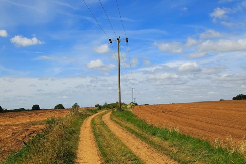 Rural electricity supply lines running across countryside, Alderton, Suffolk, England, United