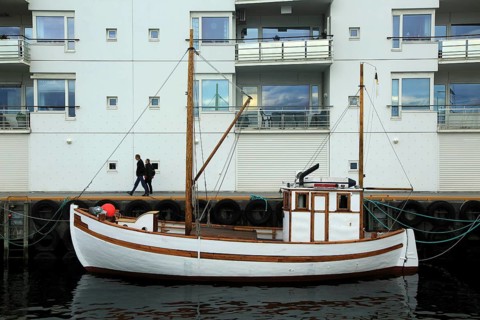 Traditional wooden boat outside modern housing apartments, Molde, Romsdal county, Norway, Europe