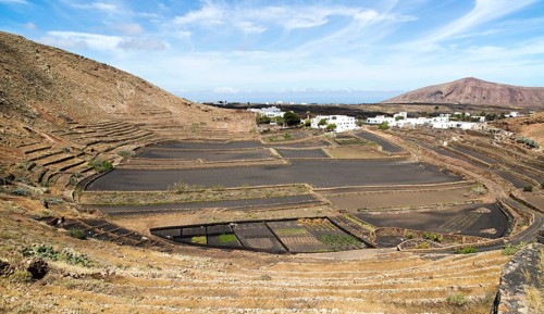 Volcano crater and black volcanic soil farmland, near Tinajo, Lanzarote, Canary Islands, Spain,
