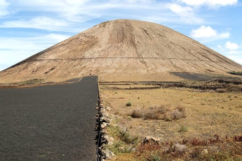 Volcano cone and black volcanic soil farmland, near Tinajo, Lanzarote, Canary Islands, Spain,
