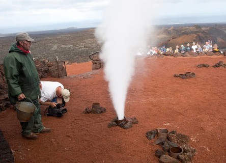 Tourists watch steam rise from geyser spout, Parque Nacional de Timanfaya, national park,