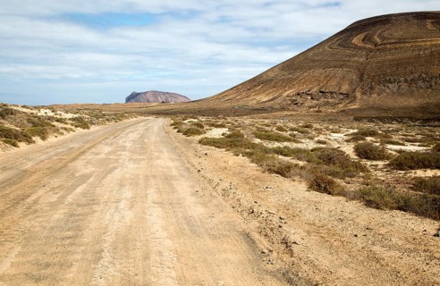 Unmade road passing Agujas Grandes volcano, La Isla Graciosa, Lanzarote, Canary Islands, Spain,