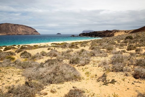 Montana Clara island nature reserve and sandy beach Playa de las Conchas, Graciosa island,