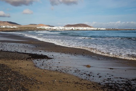 White cuboid buildings of coastal village La Caleta de Famara, Lanzarote, Canary islands, Spain,