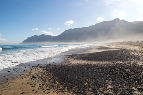 Atlantic Ocean coast beach and waves with morning sea mist, Caleta de Famara, Lanzarote, Canary
