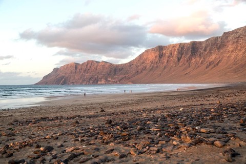 Evening sunset light on beach and cliffs La Caleta de Famara, Lanzarote, Canary islands, Spain,