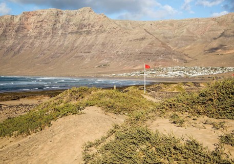 Red flag flying warning of bathing danger, La Caleta de Famara, Lanzarote, Canary islands, Spain,