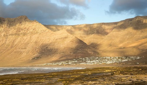 Late afternoon light on beach and cliffs La Caleta de Famara, Lanzarote, Canary islands, Spain,