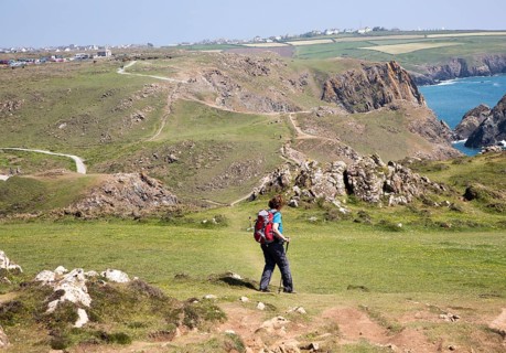 Woman walking near Kynance Cove, Lizard peninsula, Cornwall, England, UK