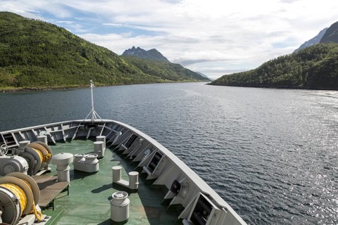 Hurtigruten ferry ship passing down fjord Raftsundet, Hinnoya Island, Nordland, northern Norway
