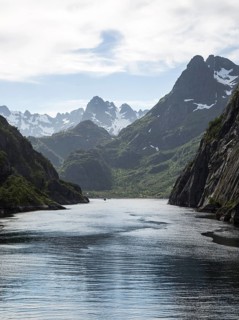 Steep sided glacial trough fiord jagged mountain peaks, Trollfjorden, Lofoten Islands, Nordland,