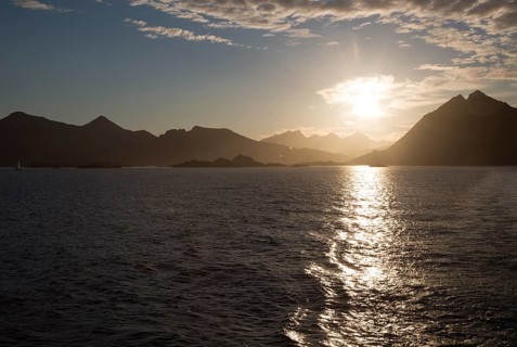Midnight sun low in sky over mountains near Stamsund, Lofoten Islands, Nordland, Norway, Europe