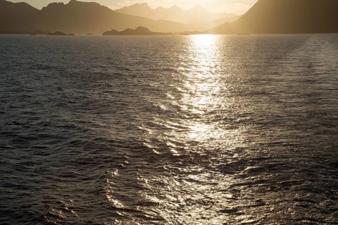 Midnight sun low in sky over mountains near Stamsund, Lofoten Islands, Nordland, Norway, Europe
