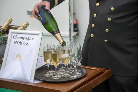 Champagne celebration crossing the Arctic Circle heading south, Norway on Hurtigruten ferry ship,