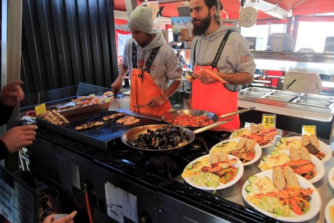 Street stall restaurant cooking fish meals in Torget market, Bergen, Norway, Europe