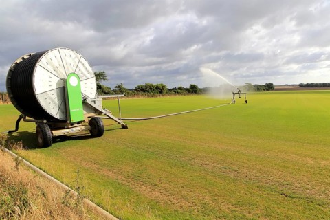 Rainstar irrigator crop sprayer field of grass turf, Alderton, Suffolk, England, UK