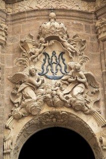 Ornately carved decorated stonework above the entrance to the cathedral church in city of Valencia,