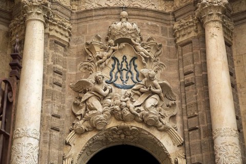 Ornately carved decorated stonework above the entrance to the cathedral church in city of Valencia,