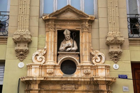 Statue of Christian bishop carved stonework of the cathedral church building in city of Valencia,