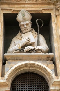Statue of Christian bishop carved stonework of the cathedral church building in city of Valencia,