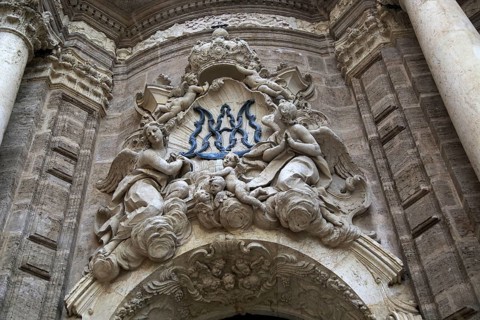 Ornately carved decorated stonework above the entrance to the cathedral church in city of Valencia,