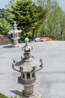 Stone carved lanterns on concrete plaza in park in Goseong, South Korea, Asia