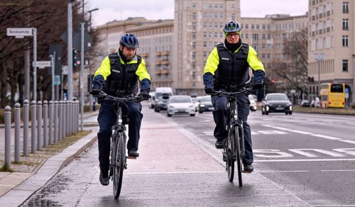 Employees of the bicycle squadron of the public order office with their bikes on a street. The