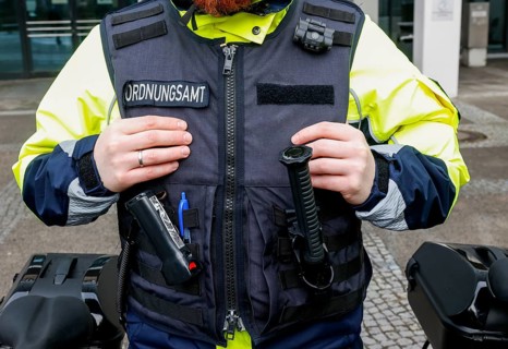 An employee of the bicycle squadron of the public order office wears a protective waistcoat,
