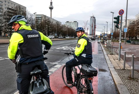 Employees of the bicycle squadron of the public order office with their bikes on a street. The