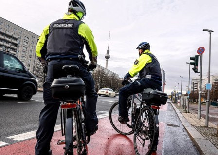 Employees of the bicycle squadron of the public order office with their bikes on a street. The