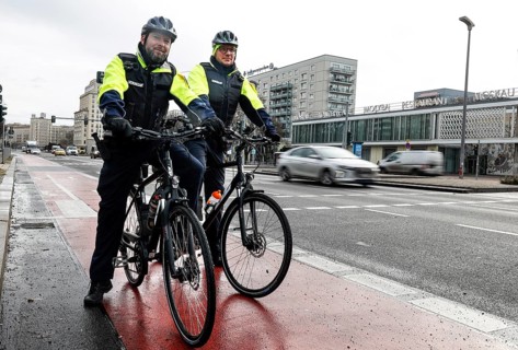 Employees of the bicycle squadron of the public order office with their bikes on a street. The