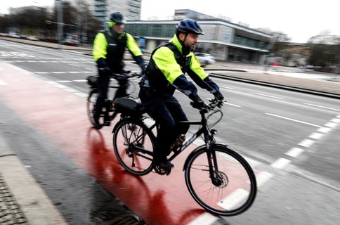 Employees of the bicycle squadron of the public order office with their bikes on a street. The