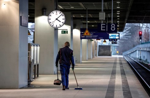 A Deutsche Bahn service employee cleans the platform at Südkreuz station. The fourth train drivers'