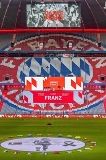 Banner with Franz Beckenbauer and wreaths of flowers, behind the speaker's stage at the end of the