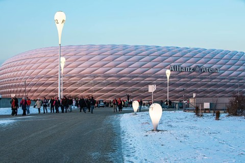 Mourners on their way home, behind them the Allianz Arena in the evening light, FC Bayern Munich