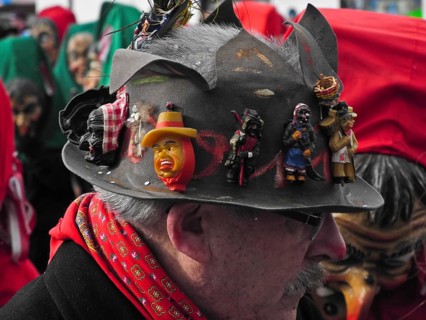 Masks on the hat of a spectator of the parade of the Swabian-Alemannic carnival in