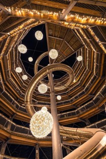 Spiral structure with fairy lights viewed from below, enchanting forest dwellers, treetop walk Bad