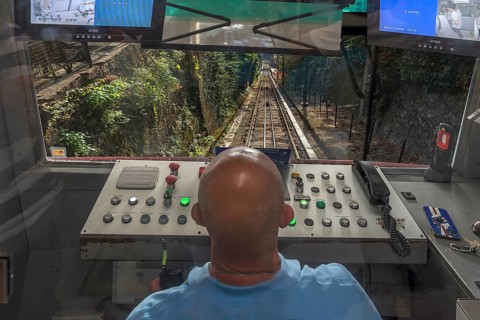 Driver at the driver's desk during the descent of the funicular funicolare Zecca Righi to the city
